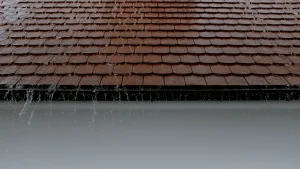 Pluie sur une toiture de tuiles et gouttière