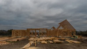 Ossature en bois d'une maison en construction sous un ciel nuageux