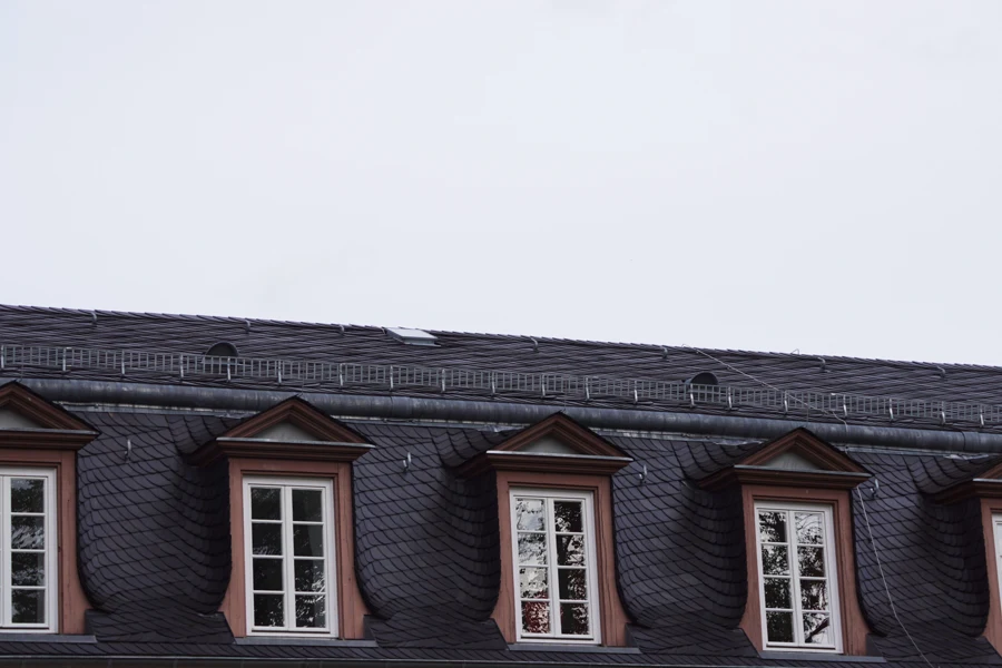 Toit en ardoise sombre avec lucarnes à fronton, repère visuel pour comparer synthétique et naturelle