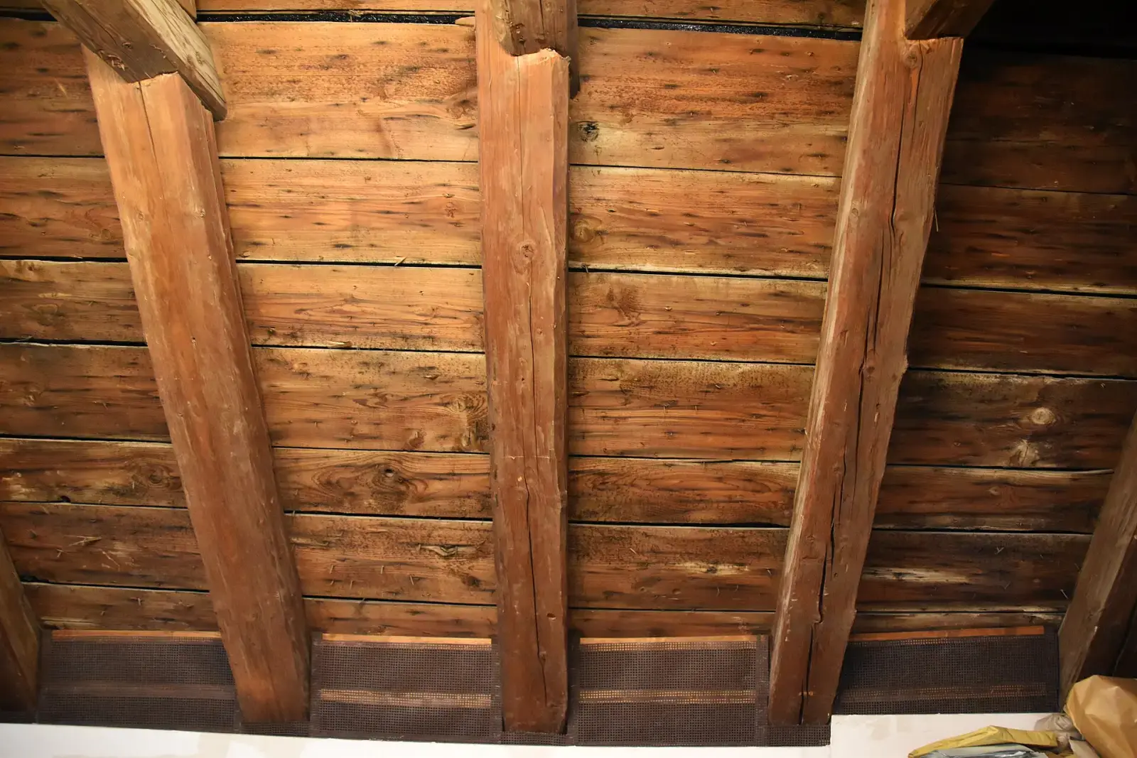 Voliges jointives clouées sur des chevrons anciens, vues depuis les combles
